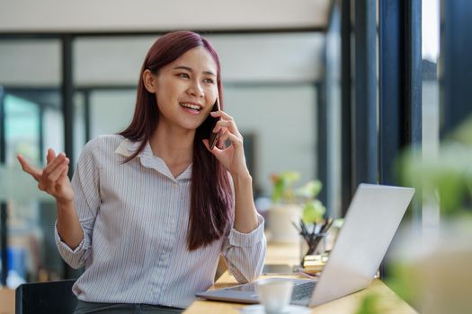 Asian businesswoman using the phone to contact a business partner.