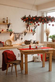The kitchen is decorated in a Christmas style with red accents. Cozy atmosphere of winter holidays.