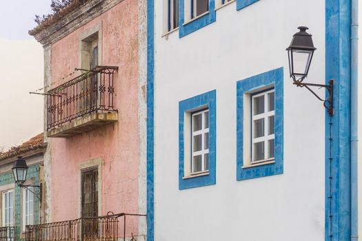 Two bright abandoned houses on a European street during the day