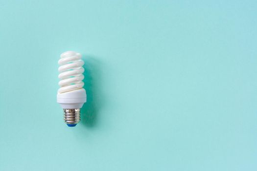 Energy saving light bulb on a blue background. Economical consumption of electricity. The concept of nature conservation