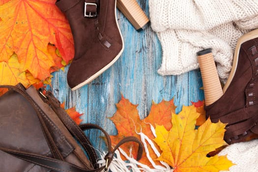 Autumn flat lay female things and maple leaves on a blue vintage background with free space for text