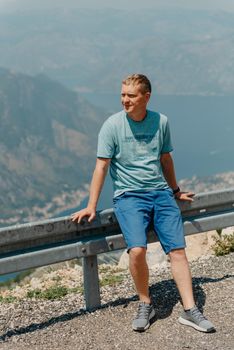 Man tourist enjoys the view of Kotor. Montenegro. Bay of Kotor, Gulf of Kotor, Boka Kotorska and walled old city. Travel to Montenegro concept. Fortifications of Kotor is on UNESCO World Heritage