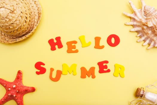 The words Hello Summer on a yellow background with a shell, hat, starfish. The concept of vacation, warmth, summer, adventure