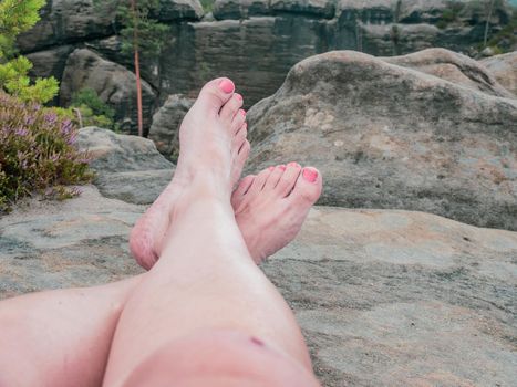 Tired legs of female traveler resting on top of mountain outdoor. Travel concept