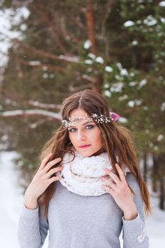 Beautiful bride in a white dress with a bouquet in a snow-covered winter forest. Portrait of the bride in nature.Beautiful bride in a white dress with a bouquet in a snow-covered winter forest. Portrait of the bride in nature.