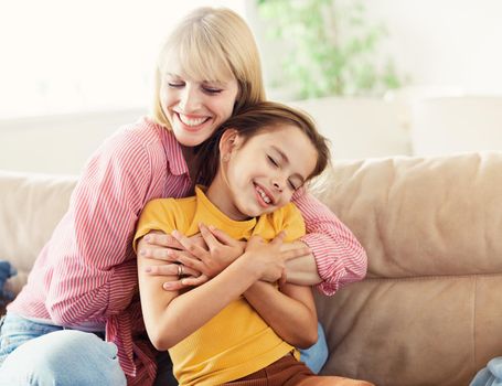 Portrait of happy mother and daughter having fun at home