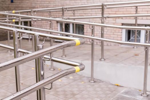 Way of wheelchair, concrete ramp way with stainless steel handrail with disabled sign on the floor for support wheelchair of disabled people and stairs for normal people.