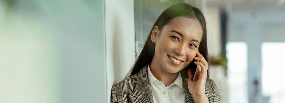 Asian business woman making a phone call and smiling. High quality photo