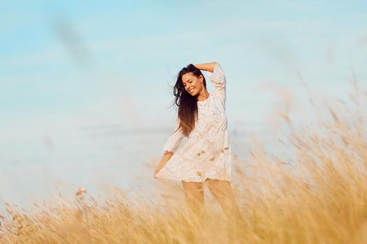 Portrait of a young beautiful girl posing outdoors in the field