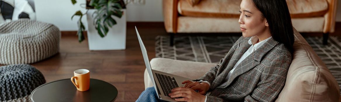 Attractive asian business woman working laptop sitting in cozy office. High quality photo