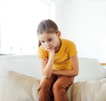 Portrait of a sad child, a little girl, while parents are having an argument at home