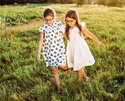 Happy little girls walking playing outdoors