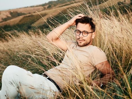 Portrait of a young man fashion model outdoors in the field