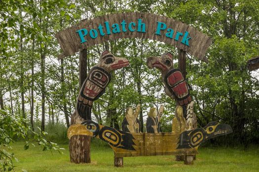 Ketchikan, AK - 10 June 2022: Totem poles and welcome sign in Potlatch Park in Ketchikan Alaska
