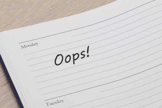 An oops diary reminder appointment open on desk