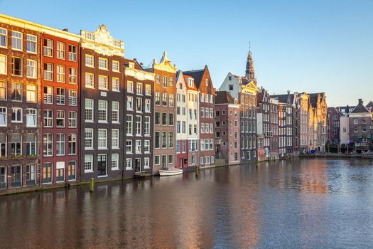 Amsterdam canal with houseboats and dutch architecture at sunrise, Netherlands