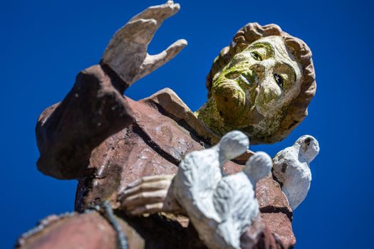 San Francisco of Assisi blessing all of us with peaceful doves at clear sky