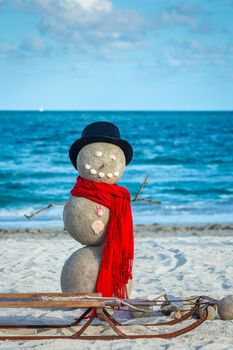 Snowman with red scarf, Hat and sled on the south Miami Beach, Florida