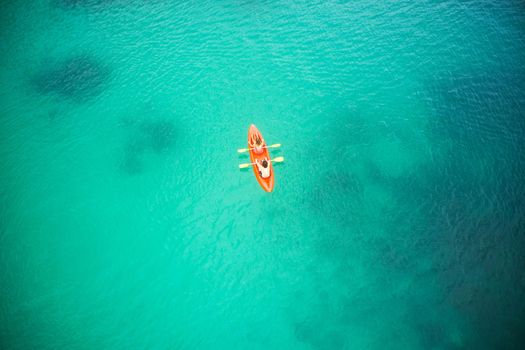 The greatest adventures in life are found out at sea. High angle shot of an adventurous young couple canoeing together in the beautiful oceans of Indonesia