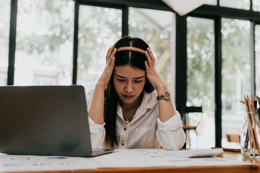 Upset woman touching head using calculator and laptop for calculating finance. Frustration young housewife with headache taxing, accounting, statistics and credit analytic for mortgage payment