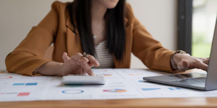Business woman using calculator and laptop doing math finance in office. tax, accounting, statistics and analytic research concept.