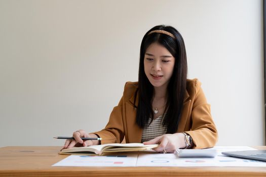 accounting is recording the company's financial growth statistics using graphs as a reference for reviewing and analyzing the results, Taking notes and analyzing data graphs in office