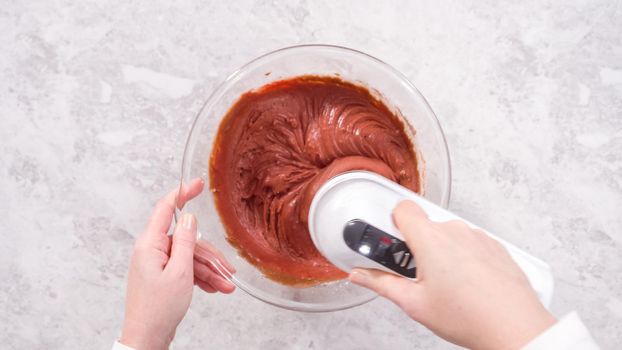 Flat lay. Step by step. Mixing ingredients in a glass mixing bowl to prepare red velvet bundt cake.