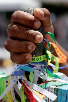 salvador, bahia / brazil - january 15, 2015: hand holds Senhor do Bonfim ribbon during traditional washing of Bonfim church stairs in the city of Salvador.