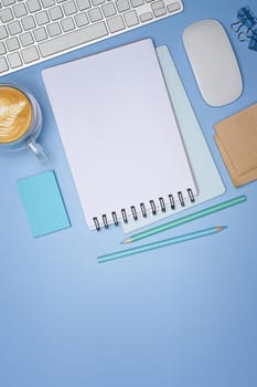 Empty notepad, coffee cup and sticky notes on blue background.