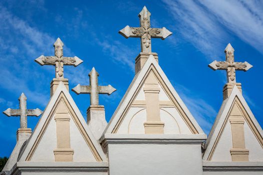 Pattern of crosses tombstones in Cemetery in a row and blue sky