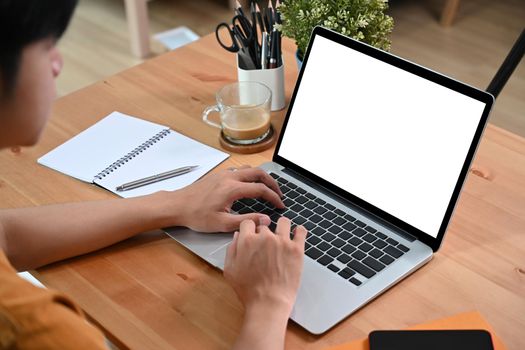 Young asian man working online with laptop computer.