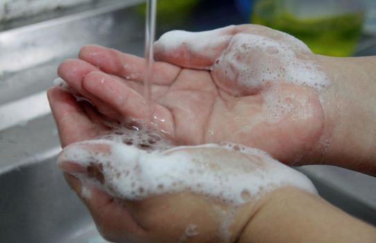 salvador, bahia / brazil - january 17, 2015: person washing hands in kitchen sink in the city of Salvador.




