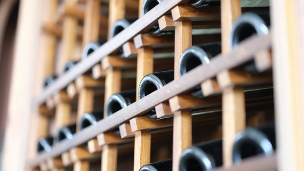 Many wine bottles in wine cellar closeup. Premium alcohol in store concept