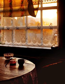 Dining room of veranda in summer house in sunset, country home of countryside in golden hour, cozy still life of rustic mood with light backlight from window and dark shadows of twilight