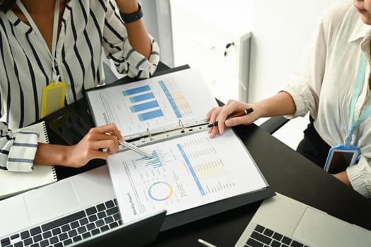 Cropped shot two business colleagues analyzing financial reports together.