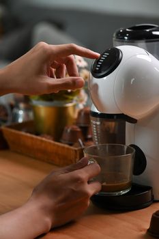 Close up view man making coffee with a coffee machine.