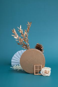 Still life of gold and white elements on a turquoise background. Minimalistic autumn concept.