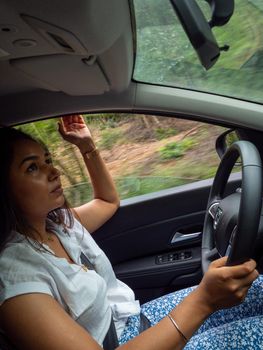 Beautiful business lady driving her car a cloudy day in summertime