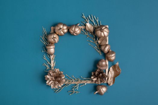 golden pumpkins and acorns with frame for text on a turquoise background. Minimalistic thanksgiving day concept