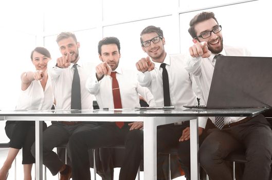 group of employees sitting at the Desk and pointing at you.the concept of choice