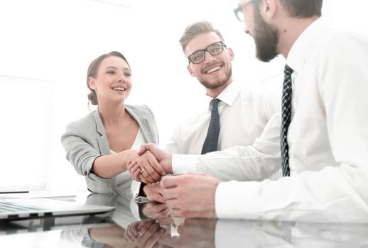 background image.handshakes colleagues at the Desk .business concept