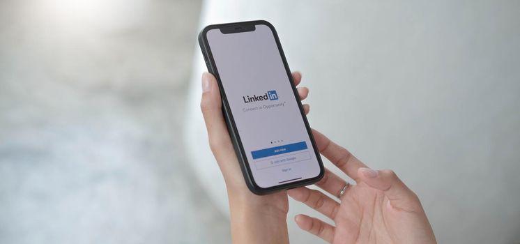 CHIANG MAI, THAILAND, JUL 12, 2022 : A women holds Apple iPhone Xs with LinkedIn application on the screen.LinkedIn is a photo-sharing app for smartphones..