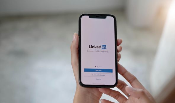 CHIANG MAI, THAILAND, JUL 12, 2022 : A women holds Apple iPhone Xs with LinkedIn application on the screen.LinkedIn is a photo-sharing app for smartphones.