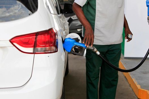 salvador, bahia, brazil - may 17, 2022: gas station attendant fills up with gasoline and vehicle at a gas station in the city of Salvador.