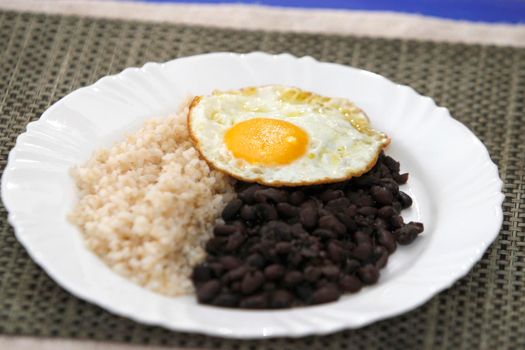 salvador, bahia, brazil - june 3, 2022: food plate with black beans, rice salad and fried egg.