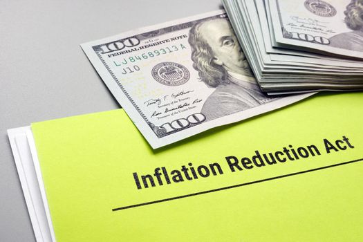 The Inflation Reduction Act of 2022 papers and cash on it.