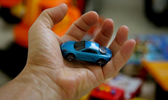 salvador, bahia brazil - may 26, 2020: hand holds replica of a miniature car.


