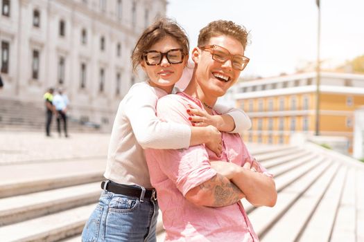 Young beautiful hipster couple in love walking on old city street, summer Europe vacation, travel, fun, happy, smiling, sunglasses, trendy outfit, romance, date, embracing