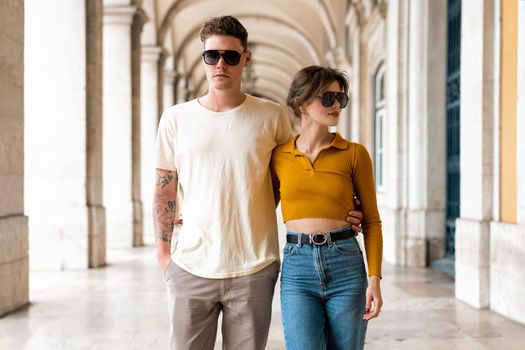 Young beautiful hipster couple in love walking on old city street, summer Europe vacation, travel, fun, happy, smiling, sunglasses, trendy outfit, romance, date, embracing