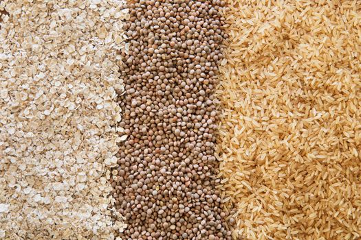 Three healthy products: brown rice, lentils, and oats as a food background.